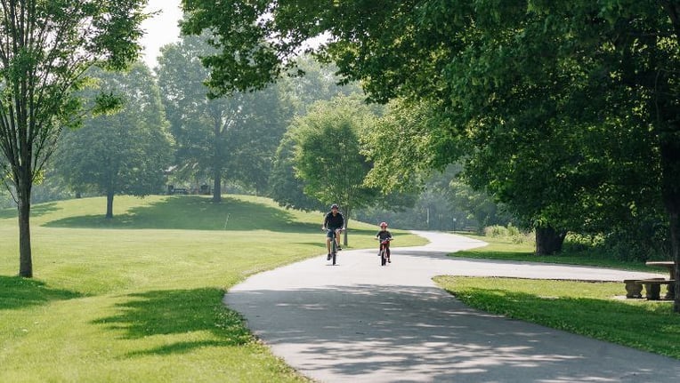 Father and son riding bikes in park located in the Town of Altavista Virginia