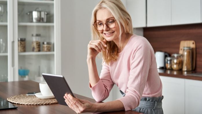 Woman using tablet in kitchen of home